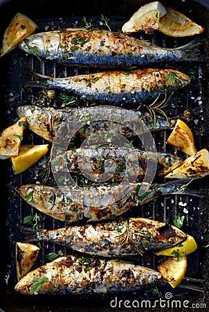 Grilled sardines in a herbal lemon marinade on a grill plate, top view Stock Photo