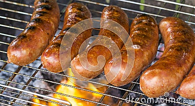 Grilled sausage on the flaming grill Stock Photo