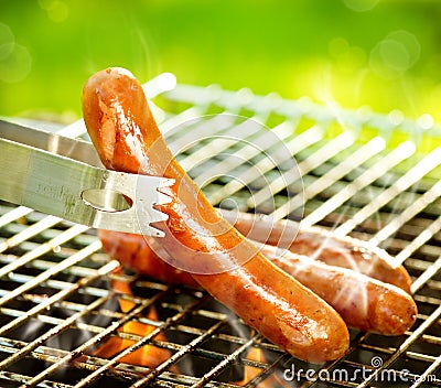 Grilled Sausage on the flaming Grill Stock Photo