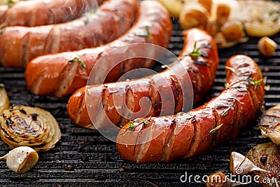 Grilled sausages with the addition of herbs and vegetables on the grill plate, outdoor, close-up Stock Photo
