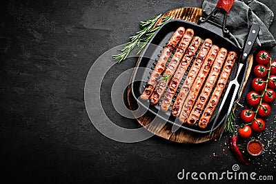 Grilled sausages bratwurst in grill frying-pan on black background. Top view. Traditional German cuisine Stock Photo