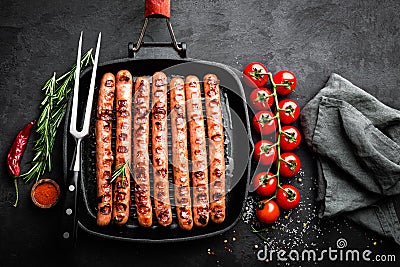 Grilled sausages bratwurst in grill frying-pan on black background. Top view. Traditional German cuisine Stock Photo