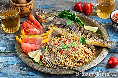 Grilled sea bass on coper plate, moroccan style Stock Photo
