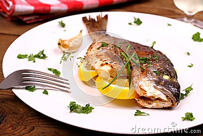 Grilled sea bream fish, lemon on white plate Stock Photo