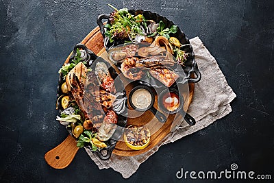 Grilled seafood platter. Assorted delicious grilled seafood with vegetables. Grilled mixed bastards with pepper sauce Stock Photo