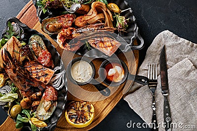 Grilled seafood platter. Assorted delicious grilled seafood with vegetables. Grilled mixed bastards with pepper sauce Stock Photo