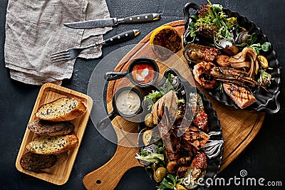 Grilled seafood platter. Assorted delicious grilled seafood with vegetables. Grilled mixed bastards with pepper sauce Stock Photo