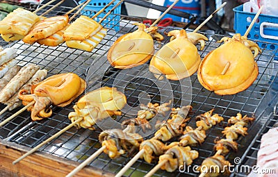 Grilled squid on steel grating Stock Photo