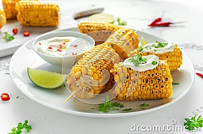 Grilled sweet corn with white mexican sauce, chilli and lime. healthy summer food Stock Photo