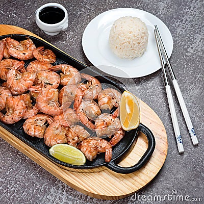 Grilled tiger shrimps with spices, lime and lemon, rice and soy sauce. Prawns fried with herbs. Grilled seafood served in chinese Stock Photo