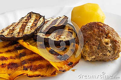 Grilled vegetables, cutlet and potatoes on a plate. Dinner for the family. A portion. Healthy diet. Concept. Blurred Stock Photo