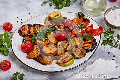 Grilled vegetables: eggplant, zucchini, potatoes, bell pepper, mushrooms, tomatoes. Served with yogurt sour cream sauce. Stock Photo