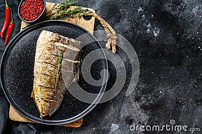 Grilled Yellowtail, Japanese amberjack fillet on a plate. Black background. Top view. Copy space Stock Photo