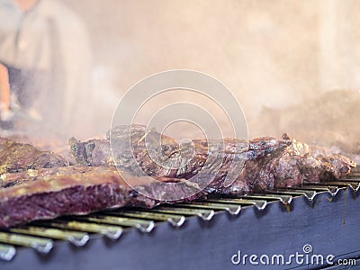 Grilling red meat and sausages at sunset outdoors gathering with Stock Photo