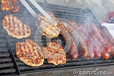 Grilling sausages, burgers, pork steak on barbecues gas grill for party. Hot dogs,sausages and hamburgers on a barbeque, bbq. Smok Stock Photo