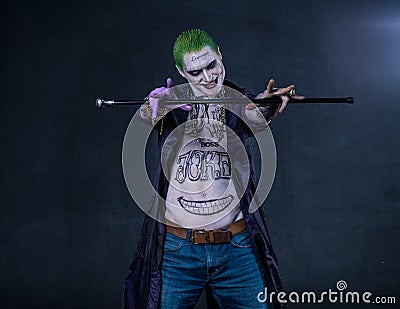 Grim evil character with drawings on the body keeps the stick. green hair Stock Photo