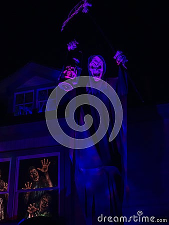 Grim Reaper Standing in Graveyard with Lantern and Scythe Stock Photo