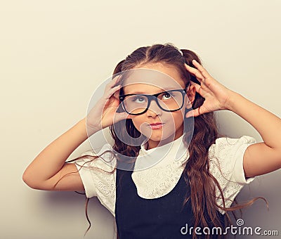 Grimacing pupil girl with long hair style in fashion eyeglasses in uniform making dreaming physiognomy Stock Photo