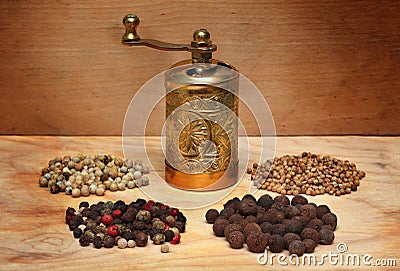 Grinder and spices on a wooden board Stock Photo