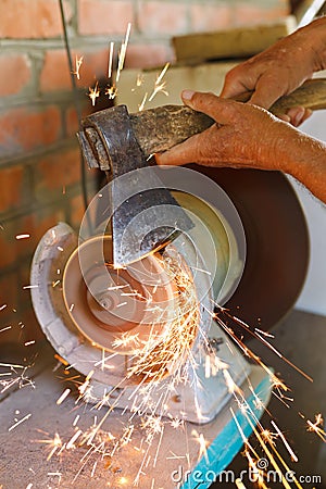 Grinding bench axe using a grinding machine Stock Photo