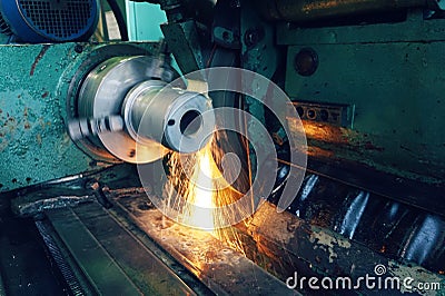 Grinding of metal, final processing of a part on a precision grinding machine with sparks and cooling. Stock Photo