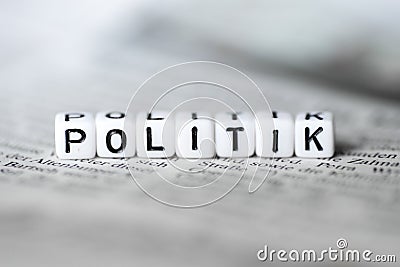 Grman Word POLITIK formed by wood alphabet blocks on newspaper Stock Photo