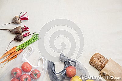 Groceries in reusable bags on natural flax or hemp background, top view. Stock Photo