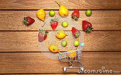 Grocery carts and summer fruits on the wooden floor. plum loquat and strawberries Stock Photo