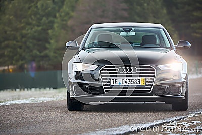 GRODNO, BELARUS - DECEMBER 2019: Audi A6 4G, C7 2016 black metallic front view headlights on outdoors on winter empty Editorial Stock Photo