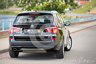 GRODNO, BELARUS - JUNE 2020: BMW X3 II F25 2.0i xDrive selective focus three fourth upper back view with wheels turned Editorial Stock Photo