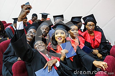 GRODNO, BELARUS - JUNE, 2018: Foreign african medical students in square academic graduation caps and black raincoats during Editorial Stock Photo