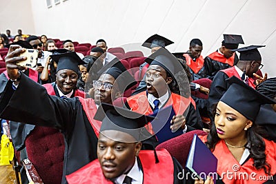 GRODNO, BELARUS - JUNE, 2018: Foreign african medical students in square academic graduation caps and black raincoats during Editorial Stock Photo