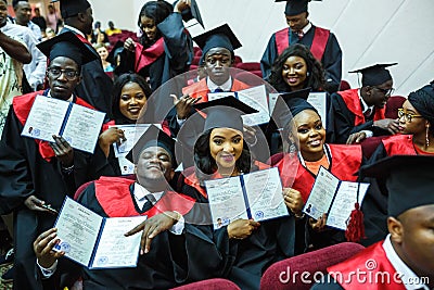 GRODNO, BELARUS - JUNE, 2018: Foreign african medical students in square academic graduation caps and black raincoats during Editorial Stock Photo