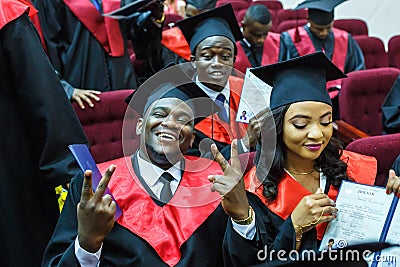 GRODNO, BELARUS - JUNE, 2018: Foreign african medical students in square academic graduation caps and black raincoats during Editorial Stock Photo