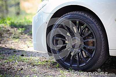 Modern luxury BMW 750Li XDrive car detailed with Mansory black alloy wheels and Falken tires close-up Editorial Stock Photo