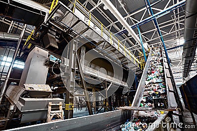 GRODNO, BELARUS - OCTOBER 2018: recycling plant conveyor belt transports garbage inside drum filter or rotating cylindrical sieve Editorial Stock Photo