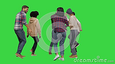 Groep gelukkige jonge mensen die samen dansen op een chromakleurensleutel met een groen scherm. stock footage Groep gelukkige jonge mensen die samen dansen op een chromakleurensleutel met een groen scherm. stock footage