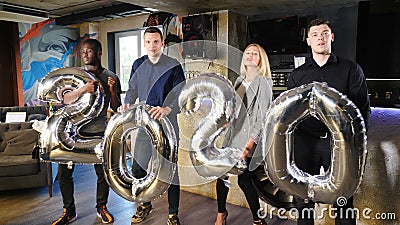 Groep jonge vrienden die het nieuwjaar 2020 vieren Schaakzame mensen houden opblaasbare folie-cijfers 2020 vast en gooien ze naar stock video Groep jonge vrienden die het nieuwjaar 2020 vieren Schaakzame mensen houden opblaasbare folie-cijfers 2020 vast en gooien ze naar stock video