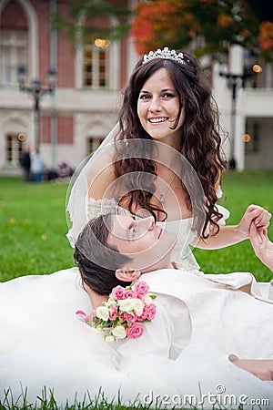 Groom and bride relaxing on a grass Stock Photo