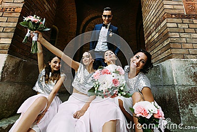 Groom with the charming bridesmaids with the bouquets Stock Photo