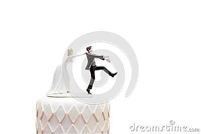 Groom doll and statue is running away but bride can catch him finally. the funny wedding story doll on the top of cake with Stock Photo