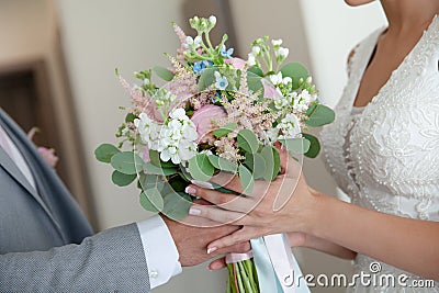 Groom giving elegant wedding bouquet to his bride. Beautiful wedding bouquet Stock Photo