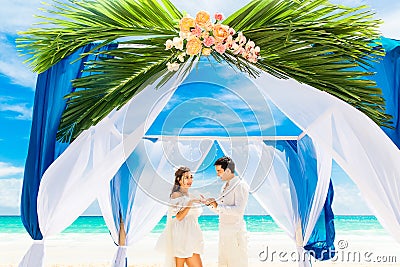 Groom giving an engagement ring to his bride under the arch deco Stock Photo