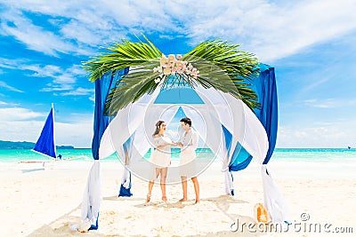 Groom giving an engagement ring to his bride under the arch deco Stock Photo