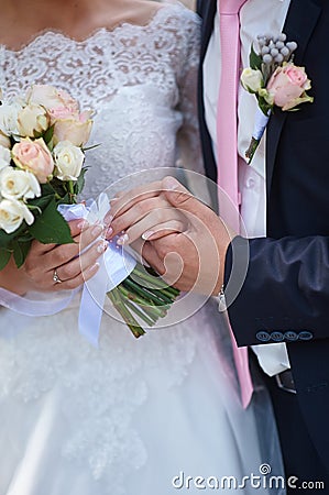 Groom holding brides hand at the wedding walk Stock Photo