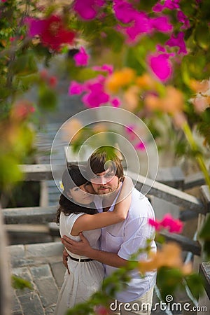 Groom hugs the bride in the garden in the summer Stock Photo