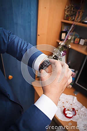 Groom looks on watch Stock Photo