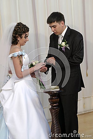 Groom placing ring on brides hand Stock Photo