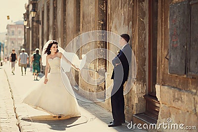 Groom posing with his beautiful bride near wall outdoors Lviv Stock Photo