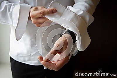 Groom putting on his cufflinks Stock Photo